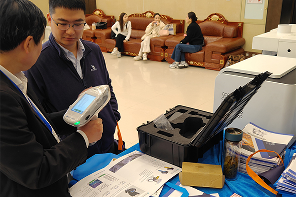 为嘉宾演示手持式光谱仪的操作